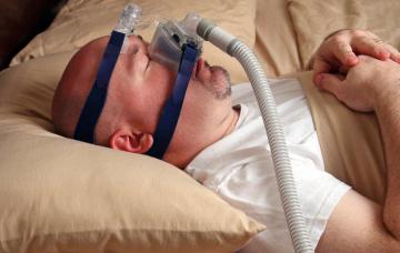 Tratamiento de la apnea del sueño Varón con una mascarilla CPAP para la apnea del sueño