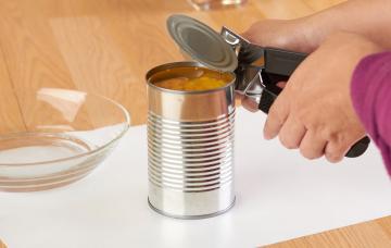 Etiquetado de los alimentos Mujer en el supermercado comprueba el buen estado de una lata