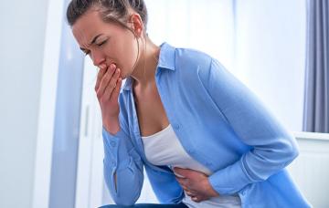 Síntomas del botulismo Mujer con dolor abdominal y náuseas