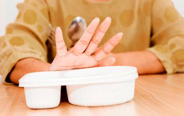 Trastornos alimenticios en la tercera edad Mano de una señora de tercera edad apartando su comida