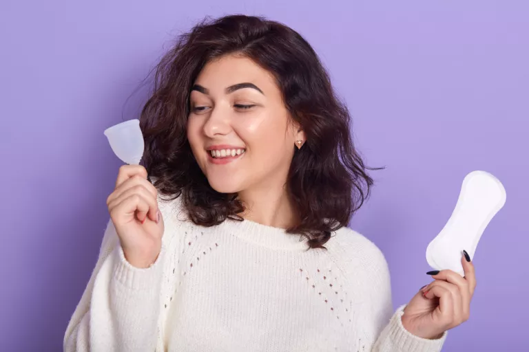 Chica eligiendo entre una copa menstrual y un salvaslip