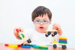 Un niño con síndrome de Down juega con unos juguetes