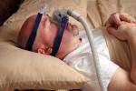 Varón con una mascarilla CPAP para la apnea del sueño