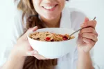 Alimentos recomendados y a evitar en el reflujo gastroesofágico Mujer tomando cereales, alimentos recomendados en el reflujo gastroesofágico