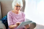 Estudian el uso que dan los adultos mayores a Internet Una mujer mayor navega por Internet con una tablet