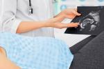 Una doctora muestra una ecografía a una mujer embarazada