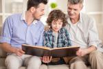 Abuelo, padre e hijo leen juntos un libro