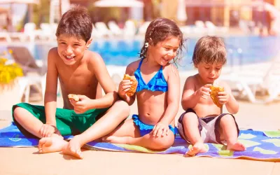 Qué es un corte de digestión Niños comiendo en la playa antes de bañarse