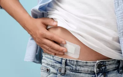 Extirpación del apéndice en un jóven Joven con parche médico tras una cirugía de extirpación del apéndice en fondo azul