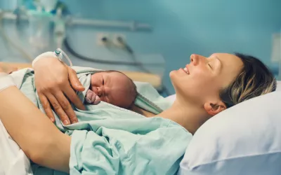 Las mujeres embarazadas reciben células fetales que permanecen en su cuerpo y su cerebro Mujer en el hospital con su recién nacido en brazos