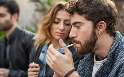Grupo de personas fumando Varios adultos jóvenes fuman al aire libre