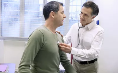 Doctor ausculta a un hombre para comprobar su función cardíaca Médico ausculta a un hombre