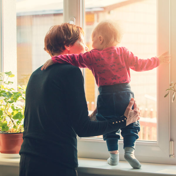 Abuela y nieto mirando a través de la ventana