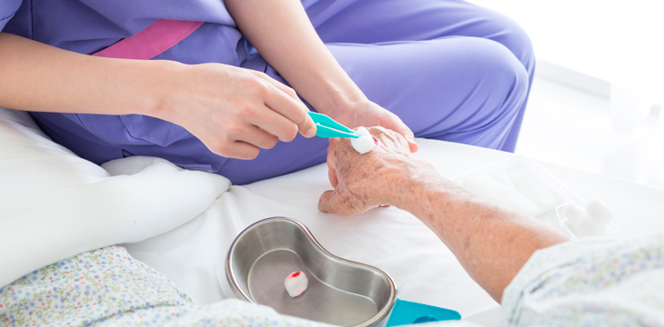 Enfermera cuidando las heridas de un anciano