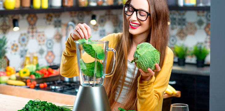 Mujer realizando un zumo de verduras