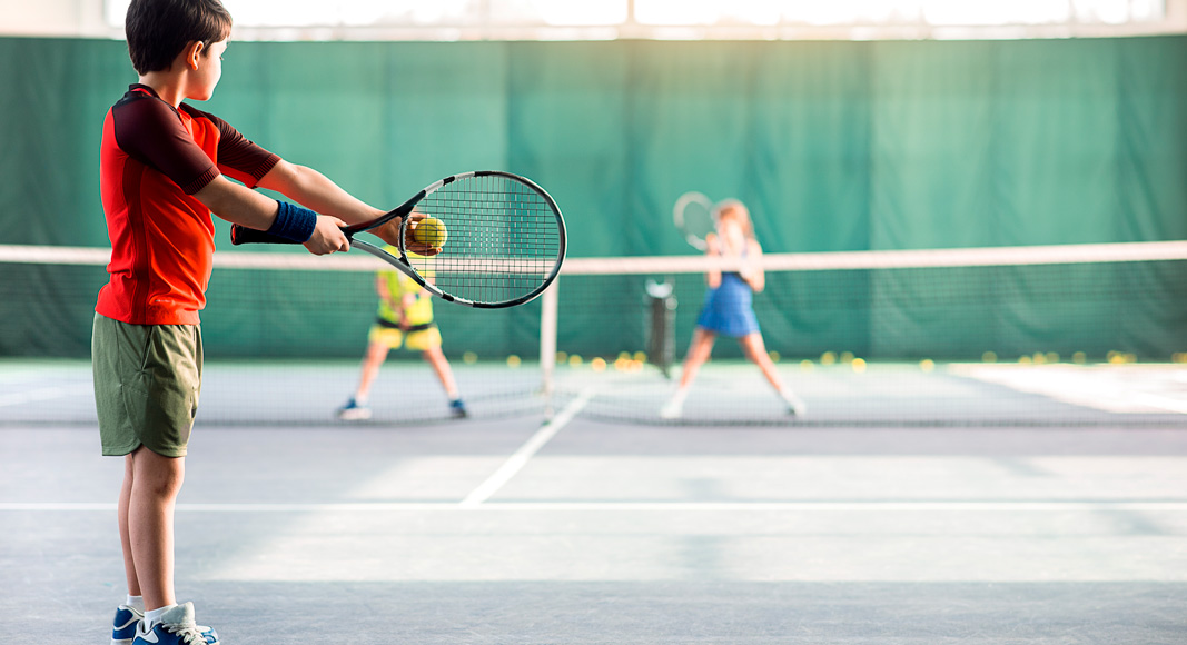 Niño jugando al tenis