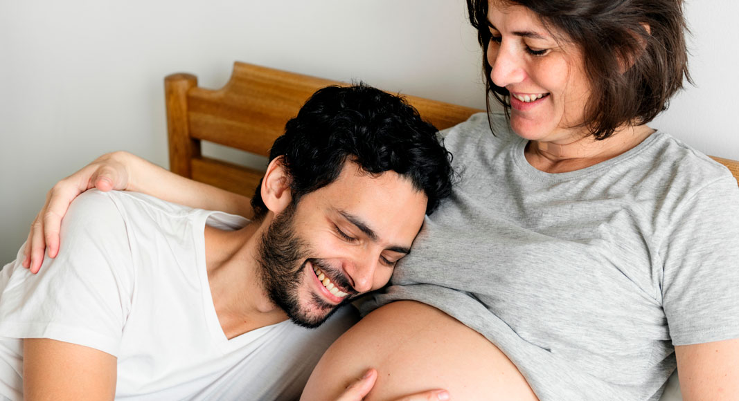 Pareja hablando a su bebé en la tripa de la madre
