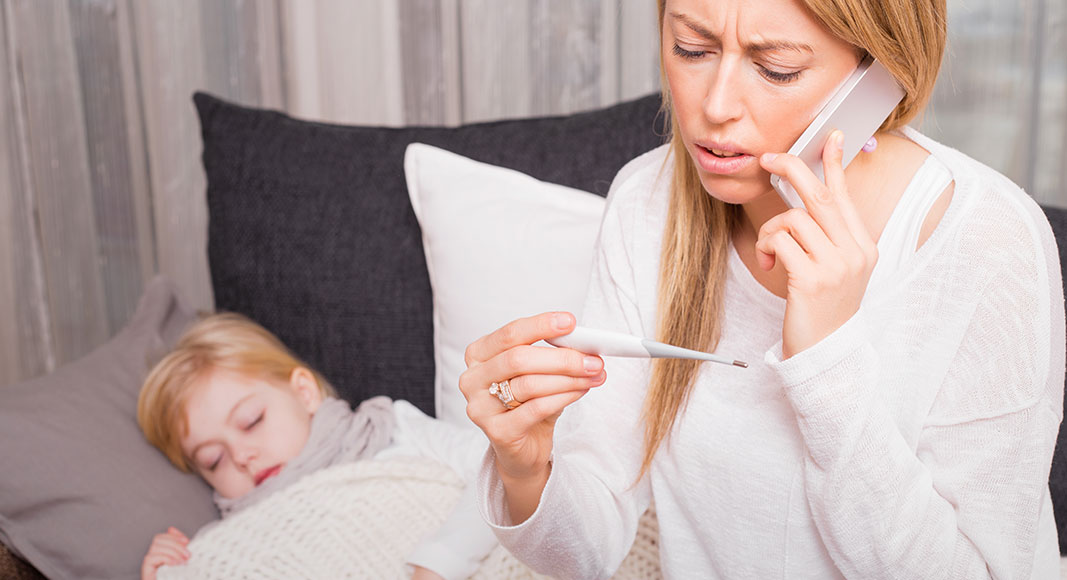 Madre llamando a los servicios sanitarios por fiebre en su hijo
