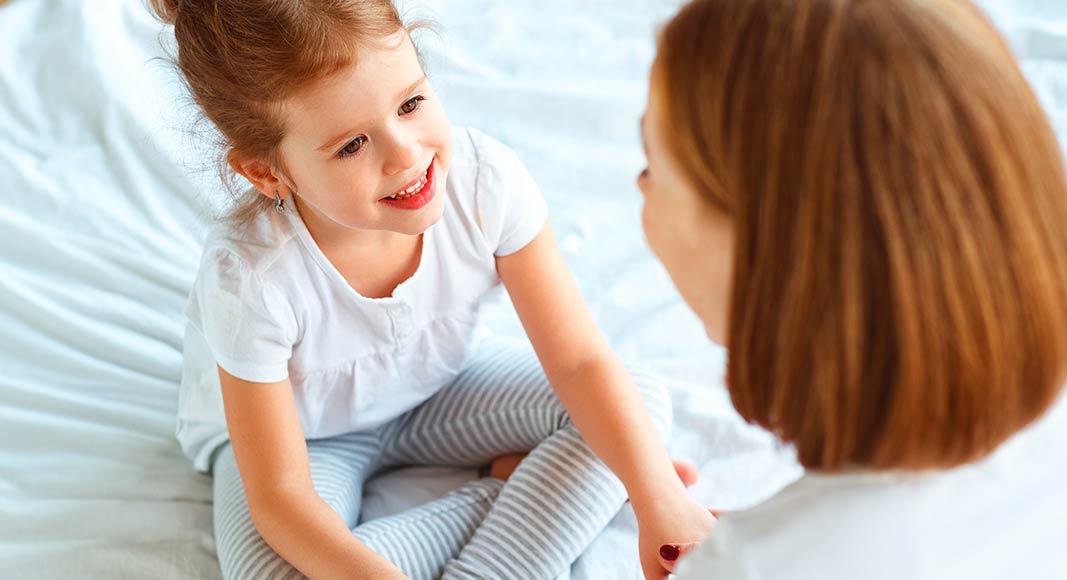 Niña realizando ejercicios de vocalización con su madre