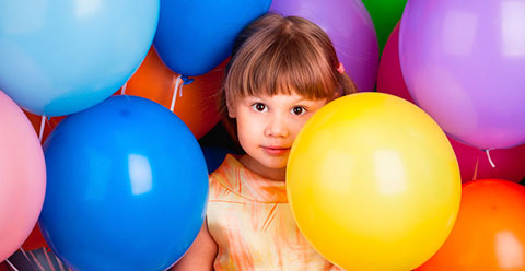 NIña jugando entre globos