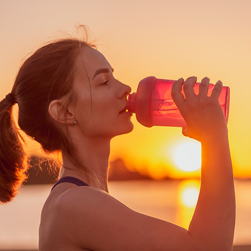 Mujer hidratándose para evitar la diarrea del corredor