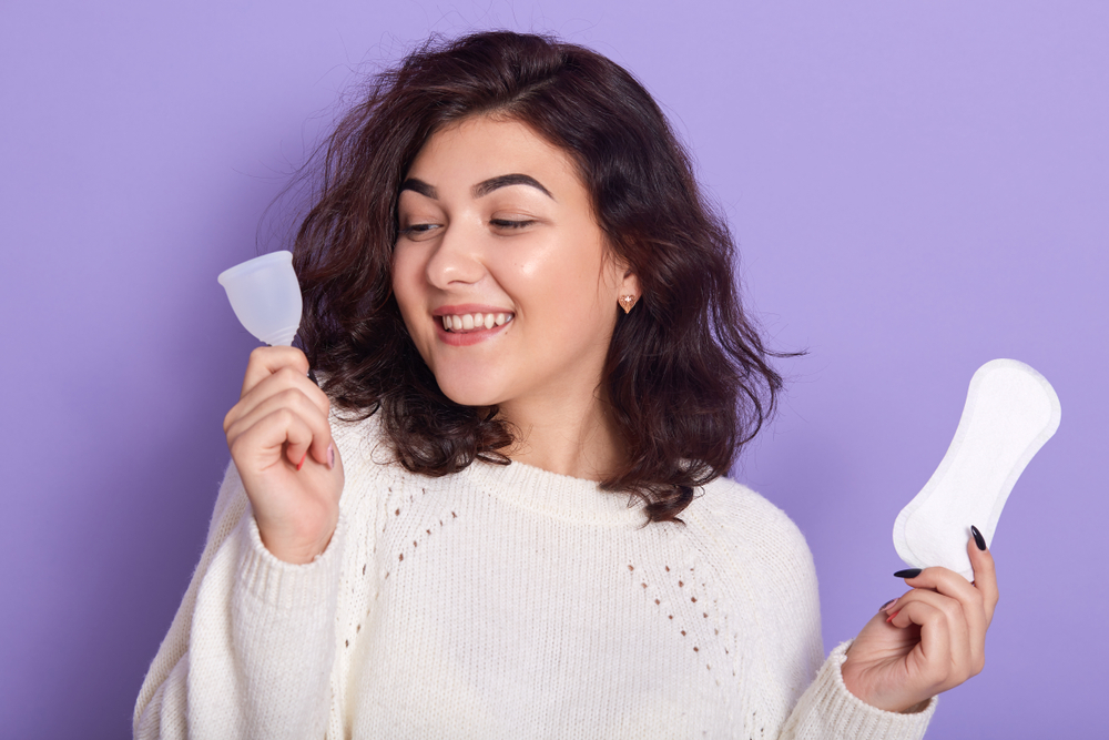 Chica eligiendo entre una copa menstrual y un salvaslip