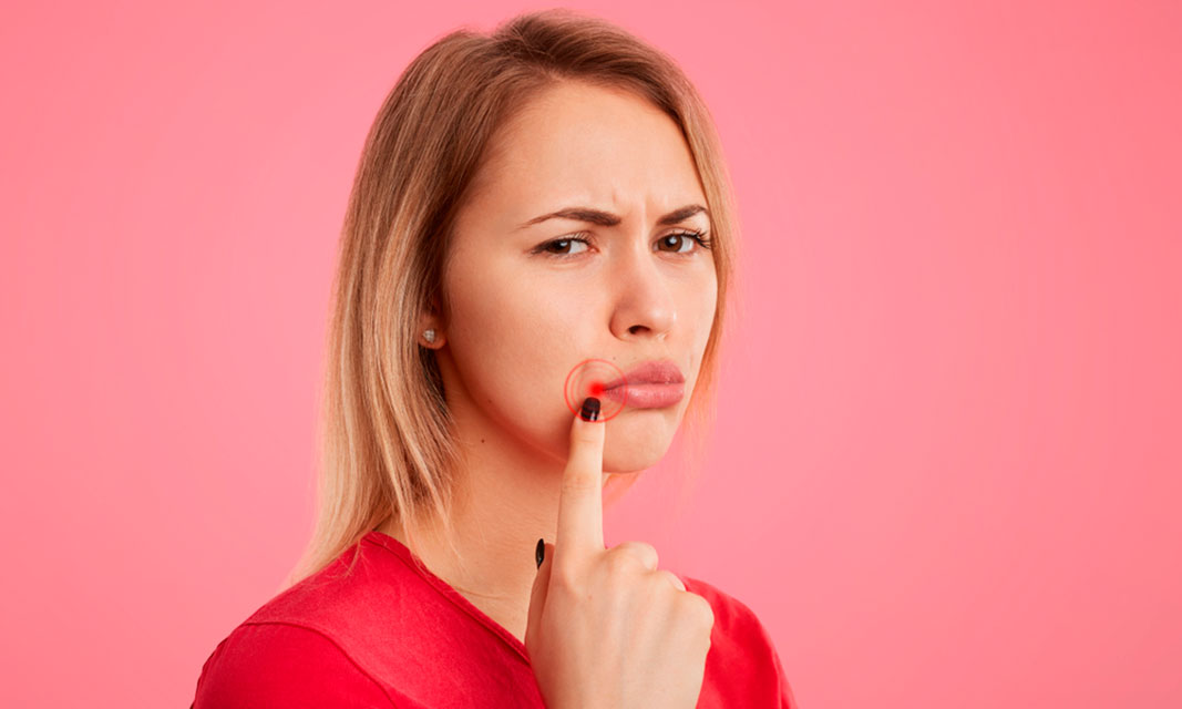 Mujer con gesto de resignación señalando su boca