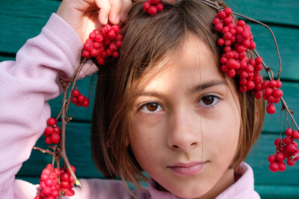 NIña con un racimo de bayas de schisandra en la cabeza