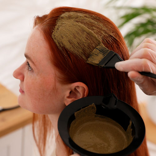 Mujer tiñendo su cabello con henna