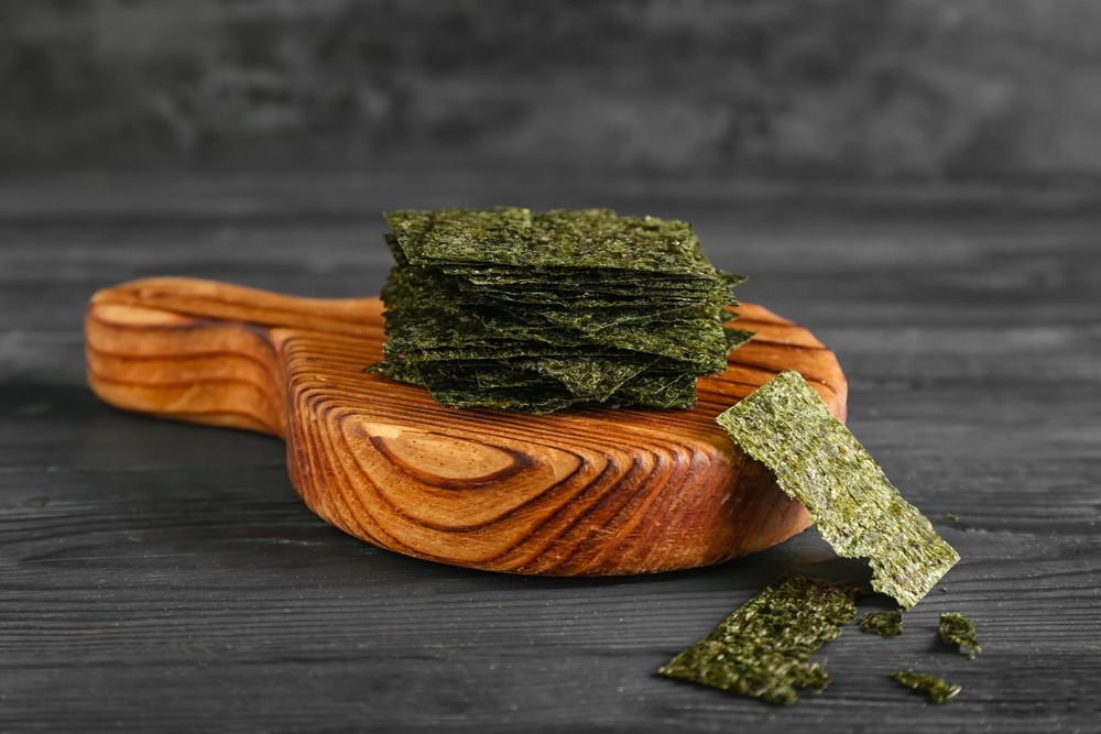 Algas nori marinas saludables y comestibles Algas nori sobre una tabla de madera