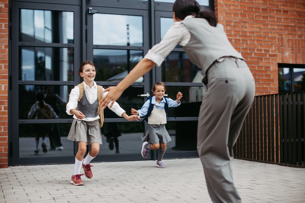 Madre recogiendo a sus hijas a la salida del colegio