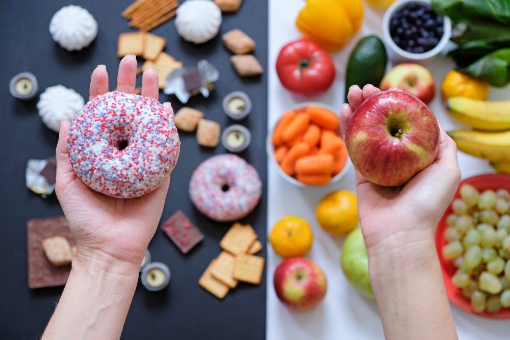 Alimentos procesados versus alimentos naturales Alimentos procesados como bollería industrial a la izquierda versus alimentos naturales como frutas a la derecha