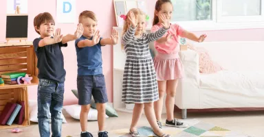 Juegos para desarrollar la inhibición conductual Niños pequeños en clase jugando al juego de la estatua