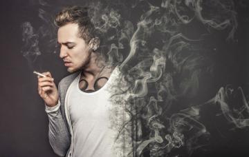 Causas del cáncer de vejiga Hombre joven fumando