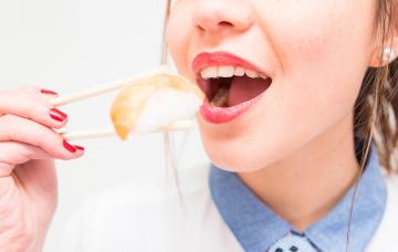 Mujer comiendo pescado crudo