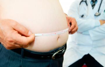 Causas de la prediabetes Hombre con sobrepeso se mide el perímetro abdominal en presencia de su médico