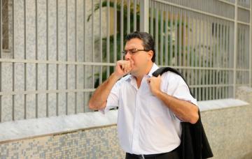 Hombre con tuberculosis tose mientras camina por la calle