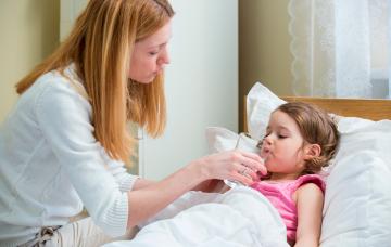 Tratamiento de la infección por norovirus y prevención Madre dando agua a su hija para recuperarse del norovirus