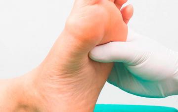 Pie diabético Un profesional sanitario examina el pie de un paciente