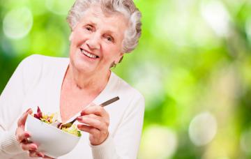 Cómo prevenir el deterioro cognitivo leve Una mujer mayor a punto de tomarse una ensalada