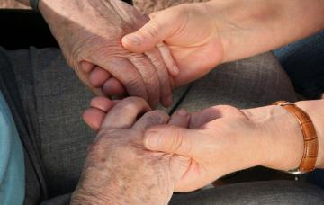 Síntomas del alzhéimer Agarrando las manos de paciente con síntomas del alzhéimer