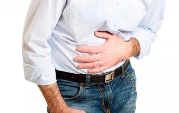 Un hombre se sujeta el abdomen dolorido