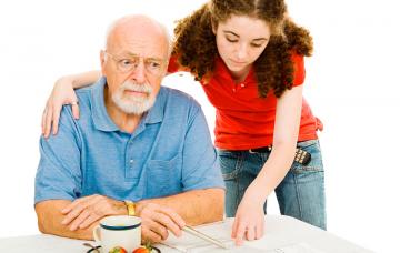 Una cuidadora atiende a un anciano con demencia