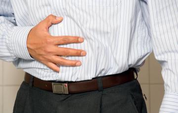 Síntomas de hígado graso Hombre se toca el abdomen dolorido