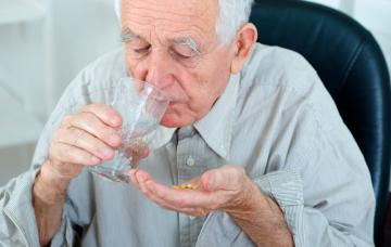 Persona mayor tomando pastillas para la demencia