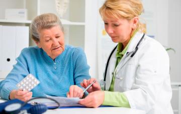 Tratamiento de la enfermedad de Paget Una doctora prescribe un tratamiento a una anciana