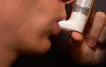 Tratamiento de la fibrosis quística Paciente medicándose con un inhalador