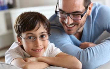 Un padre y su hijo, ambos con gafas para corregir la miopía