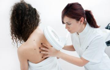 Diagnóstico de la alergia al sol Dermatólogo observando la piel de paciente con alergia al sol
