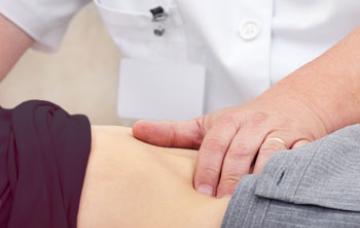 Diagnóstico del cáncer de hígado Doctor palpa el vientre de un paciente para detectar un cáncer de hígado